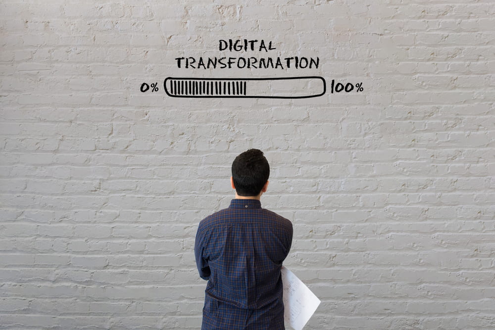 Man staring at wall with message saying "Digital Transformation" with a progress bar